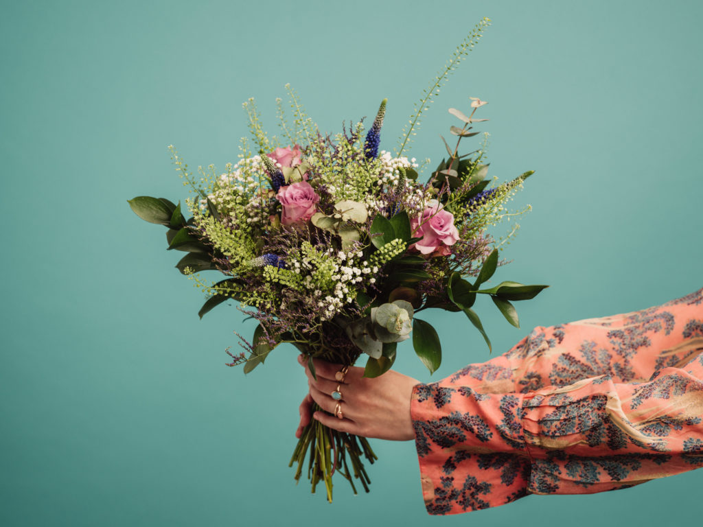 Großer Blumenstrauß vor einer türkiesen Wand